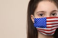 Little girl wearing mask with USA flag pattern on background, closeup. Dangerous virus