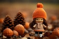 a little girl wearing an orange sweater and hat stands in front of a pile of pumpkins and pine cones