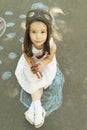 Little girl wearing a pilot hat with goggles holding in hand biplane toy