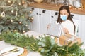 Little girl wearing protective mask on Christmas tree background. Sad child face with surgical mask. Christmas festive Royalty Free Stock Photo