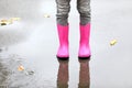 Little girl wearing rubber boots standing in puddle Royalty Free Stock Photo