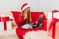 little girl wearing Santa Claus hat meets Christmas New Year via a video call on a laptop with friends  Quarantine. Self-isolation Royalty Free Stock Photo