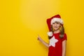 Little girl wearing Santa hat pointing towards the blank space Royalty Free Stock Photo