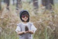 little girl wearing wool hood and sun glasses holding wild pine cones in hand Royalty Free Stock Photo