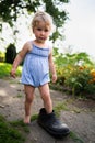 Little girl wears big grandfather`s shoe Royalty Free Stock Photo