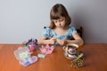 Little girl weaves a bead necklace