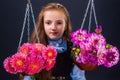 Little girl with weights, on bowls of which are autumn flowers. Royalty Free Stock Photo