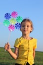Little girl with whirligig sits at grass