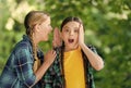 Little girl whisper in friends ear listening with curious look summer outdoors, secret Royalty Free Stock Photo