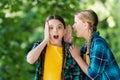 Little girl whisper in friends ear listening with curious look summer outdoors, secret Royalty Free Stock Photo