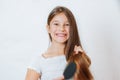 Cute smiling little girl combing her hair comb makes hair Royalty Free Stock Photo