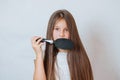 Cute smiling little girl combing her hair comb makes hair Royalty Free Stock Photo