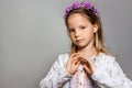 Little girl in white dress and purple wreath on gray isolated background Royalty Free Stock Photo