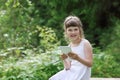 Little girl in white dress smiles and holds tablet pc Royalty Free Stock Photo