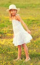 Little girl in white dress walking on the meadow Royalty Free Stock Photo