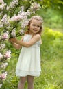 Little girl walks in the spring botanical garden where lilac blossoms Royalty Free Stock Photo