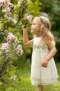 Little girl  walks in the spring botanical garden where lilac blossoms Royalty Free Stock Photo