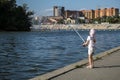 Little girl with a white fishing rod in her hands catches a fish in the river Royalty Free Stock Photo