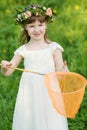 Little girl in white holds orange butterfly net on Royalty Free Stock Photo