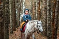 Little girl on a white pony on a background of nature. Jockey, hippodrome, horseback riding Royalty Free Stock Photo