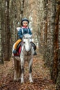 Little girl on a white pony on a background of nature. Jockey, hippodrome, horseback riding Royalty Free Stock Photo