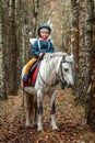 Little girl on a white pony on a background of nature. Jockey, hippodrome, horseback riding Royalty Free Stock Photo