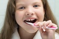 Little girl in a white robe smiling brushes her teeth, close-up Royalty Free Stock Photo