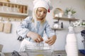 Little girl in a white shef hat cook the dough for cookies Royalty Free Stock Photo