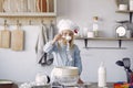 Little girl in a white shef hat cook the dough for cookies