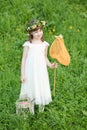 Little girl in white stands with butterfly net and Royalty Free Stock Photo