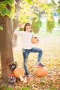 Little girl in a white sweater and jeans on a background of green textural natural background. A girl about pumpkins and conjures Royalty Free Stock Photo