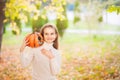 Little girl in a white sweater and jeans on a background of green textural natural background. A girl whispers in her ear a secret Royalty Free Stock Photo