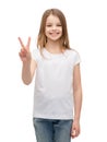 Little girl in white t-shirt showing peace gesture