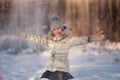 Little girl in the winter park. Girl enjoys snowing in the forest