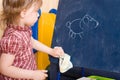 Little girl wipe drawing on a slate tablet Royalty Free Stock Photo