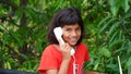 Little girl and wireless phone. Little Indian girl seeing next to a vintage white telephone Royalty Free Stock Photo