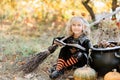 little girl in witch costume celebrate Halloween outdoor and have fun