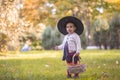 Little girl in witch costume at Halloween in autumn park with basket full of yellow leaves. Childhood, helloween Royalty Free Stock Photo