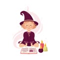 Little Girl Witch Wearing Purple Dress and Pointed Hat Practising Witchcraft and Doing Magic with Spellbook and Candles Royalty Free Stock Photo