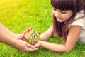 little girl and a woman hands holding small house on a background of green grass Royalty Free Stock Photo