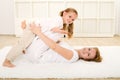 Little girl and woman playing indoors on the floor Royalty Free Stock Photo