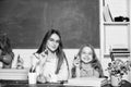 Little girl and woman sit at desk. School education. Studying together. Help with homework. Homework project. Sister Royalty Free Stock Photo