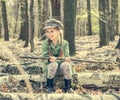 Little girl in the woods sitting on a stump Royalty Free Stock Photo