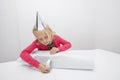 Little girl wrapping birthday gift at table in house