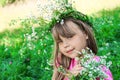 Ittle girl with flowing hair sniffs wildflowers