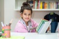 Little girl writes on the school diary