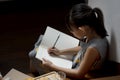 Little girl writing book and having cookie at stairway at home Royalty Free Stock Photo