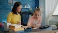 Little girl writing on notebook with pen while mother giving assistance Royalty Free Stock Photo