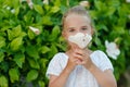 Little girl 5 years blonde smelling a flower in the summer