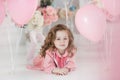 Cute six year old girl in pink dress with pink balloons in the shape of heart Royalty Free Stock Photo